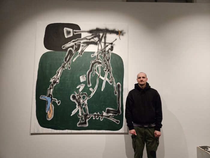 Künstler Ihor vom Socia Collective vor seinem Graffiti-Bild. Er arbeitet mit seinem Bruder aus der Ferne zusammen, der in Kyjiw geblieben ist (c) Florian Bayer
